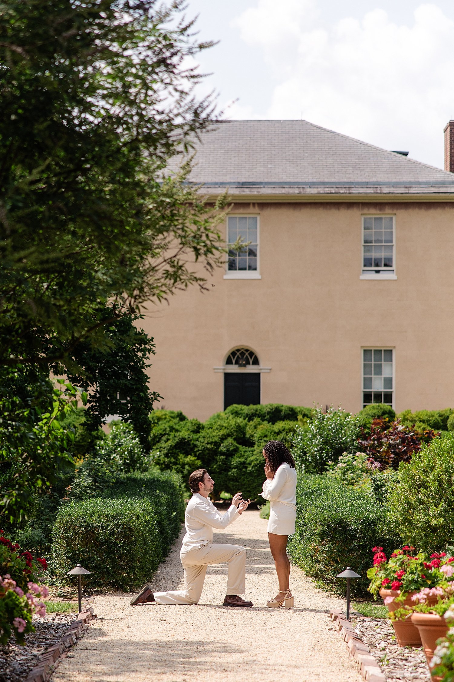 man on bended knee on garden path by Baltimore Wedding Photographer